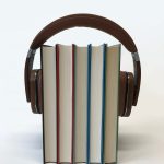 Headphones over a set of books to represent an audiobook.